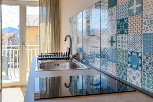 a kitchen with a sink and a tile wall at Cilento Sea Rooms in Agropoli
