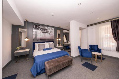 a bedroom with a large bed and two blue chairs at Skopea Inn Exclusive Hotel in Göcek