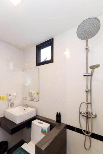 a bathroom with a sink and a toilet and a mirror at Lespalm Resort by Vacayandco in Ban Thalat Choeng Thale