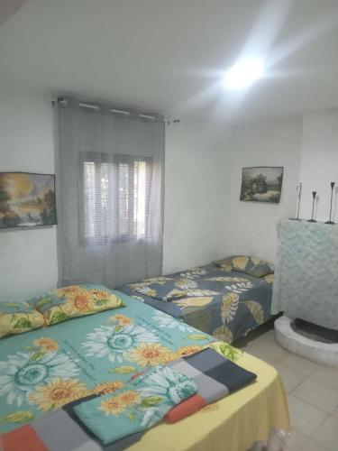 a bedroom with two beds and a table in it at Hydrovor Apartment & Room in Hamallë
