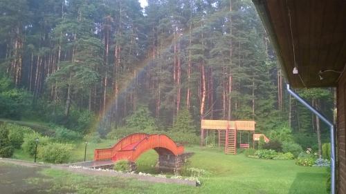 a house in the middle of a field with a forest at Oāze Smiltenē in Smiltene