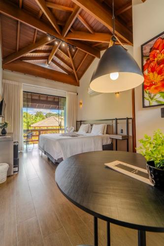a bedroom with two beds and a table in a room at Pousada Saint Diniz in Monte Sião