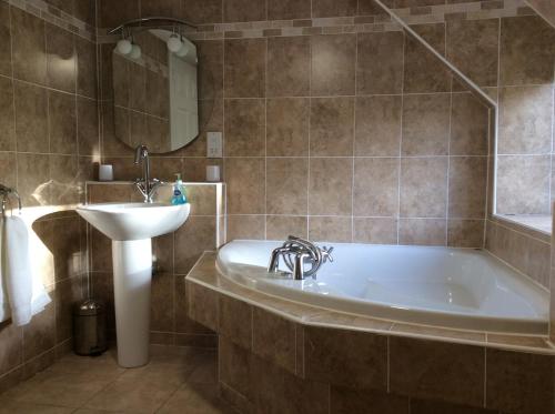 a bathroom with a tub and a sink at Craig Cottage in Banff