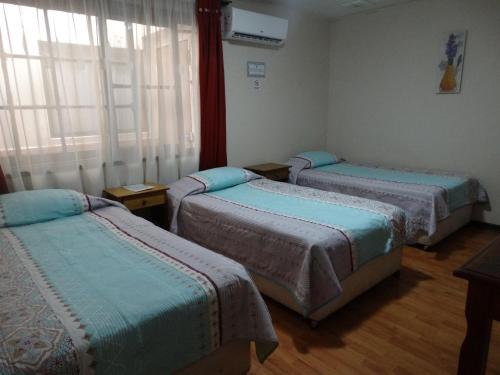 a hospital room with three beds and a window at hotel rancagua in Rancagua