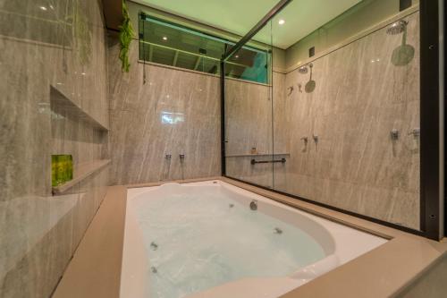 a large tub in a bathroom with a shower at Pousada Saint Diniz in Monte Sião