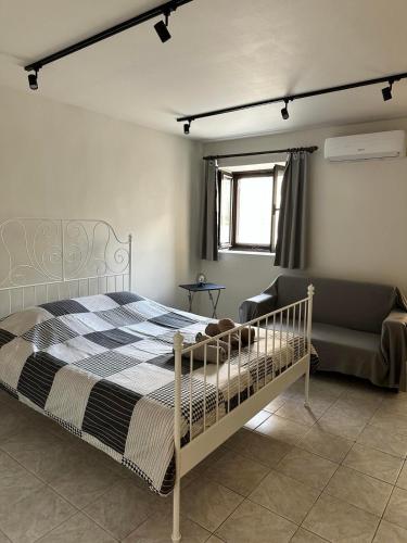 ein Schlafzimmer mit einem Bett und einer Couch in der Unterkunft Davelis House in Agios Vlasios