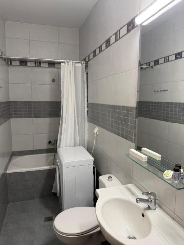 a bathroom with a toilet and a sink and a tub at ERODIOS apartments in Karistos