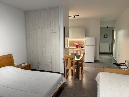 a bedroom with a bed and a table and a kitchen at ERODIOS apartments in Karistos
