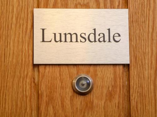 a sign on a wooden door with the word lunileaks at Lumsdale in Matlock