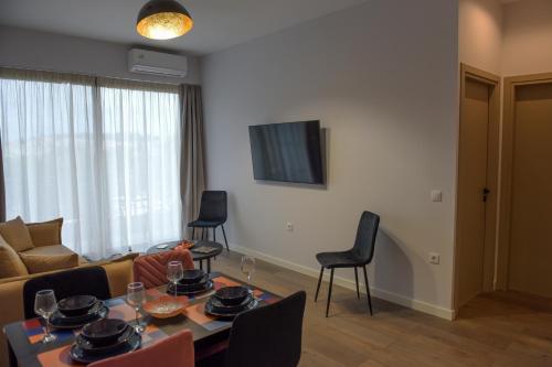 a living room with a couch and a table and chairs at The ViewPoint VP2 - Το διαμάντι της θέας in Mytilene
