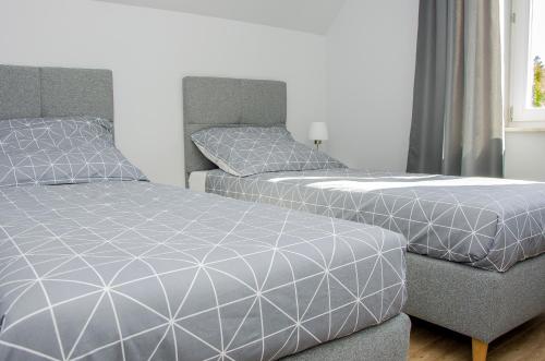 two beds and a couch in a bedroom at Apartamenty Suchacz in Suchacz