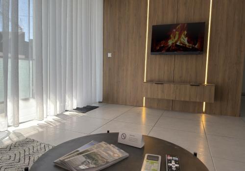 a room with a table and a tv on a wall at JAM Suite in Koblenz