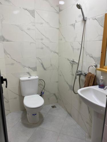 a white bathroom with a toilet and a sink at Atlantic Coast Imsouane in Imsouane