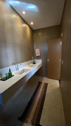 a bathroom with two sinks and a shower at Recanto das Palmeiras hidro in Hidrolândia