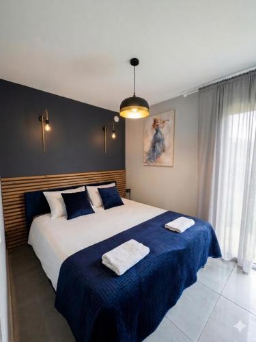 a bedroom with a large bed with two towels on it at Domki La Bella 2 in Aleksandria