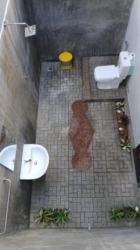 a bathroom with two sinks and a teddy bear on the floor at Kite Brothers Resort in Kalpitiya