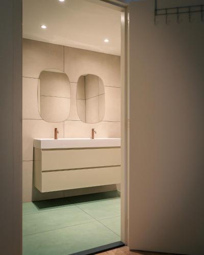 a bathroom with a sink and two mirrors at De Moolt Vakantiewoningen in Eckelrade