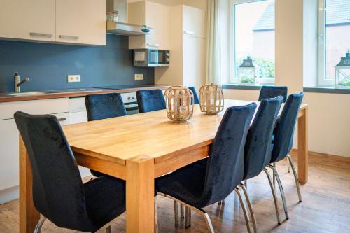 a wooden table with chairs around it in a kitchen at De Moolt Vakantiewoningen in Eckelrade
