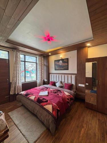 a bedroom with a large bed with a pink ceiling at Sati Heights in Vashisht