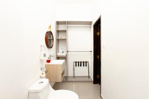 a bathroom with a white toilet and a sink at Hotel H4 El Paraíso in El Paraíso