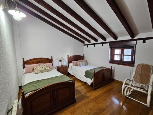 a bedroom with two beds and a window at Casa Gelín Verde in Santillana del Mar
