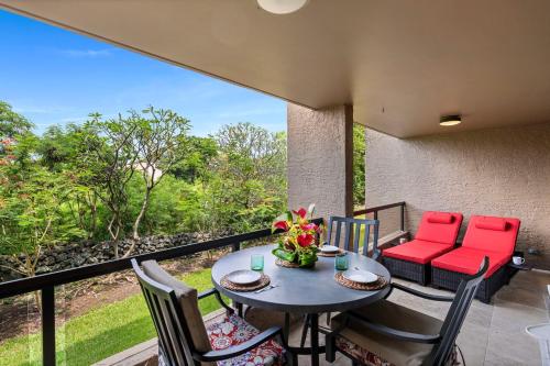 a patio with a table and chairs on a balcony at Kona Pacific C317 in Kailua-Kona