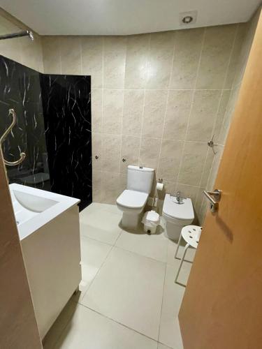 a bathroom with a white toilet and a sink at Trajadinha in Vila Praia de Âncora
