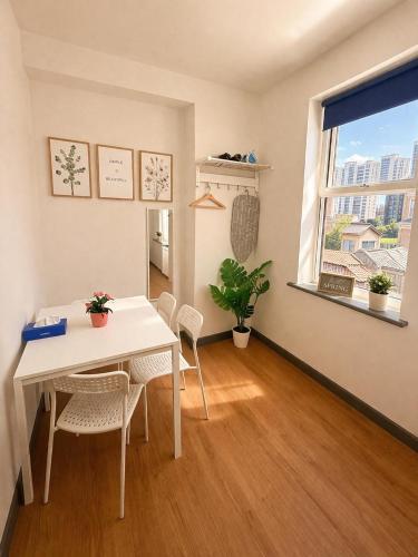a dining room with a table and chairs and a window at Kilburn Guest Rooms 167 in London