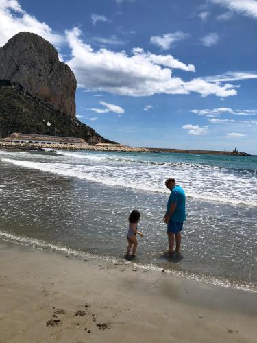 a man and a child standing on the beach at Ti Miquel in Ifach