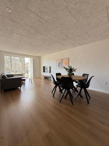 a living room with a table and chairs and a couch at Completely renovated apartment, 6 sleeps in Herning