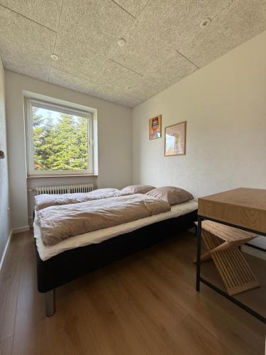 a large bed in a room with a window at Completely renovated apartment, 6 sleeps in Herning