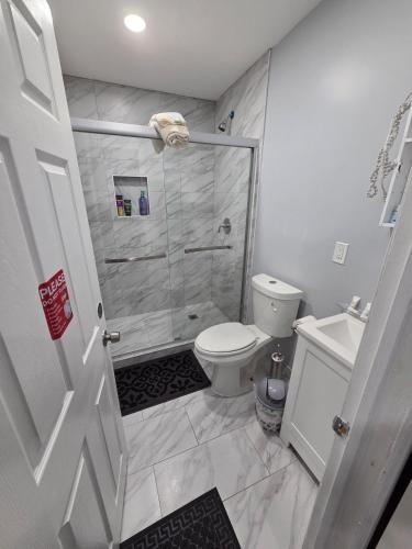 a bathroom with a shower and a toilet at Newly built Studio in Irvington
