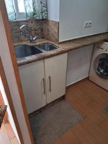 a kitchen with a sink and a washing machine at Apto a 2 minutos de playa. in Fuengirola