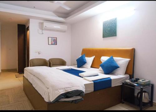 a bedroom with a bed with blue and white pillows at Hotel Blueberry in New Delhi
