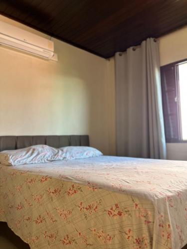 a bedroom with a bed with a blanket on it at Casa com piscina aquecida e quadra de vôlei in Osório