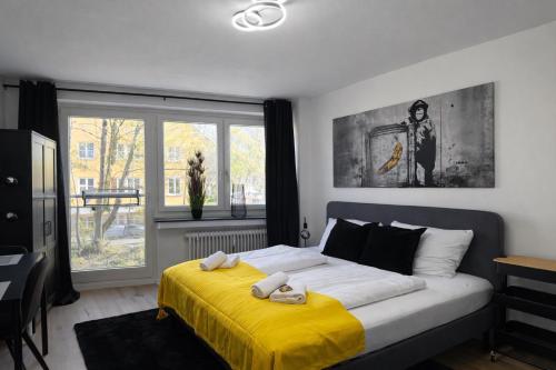a bedroom with a large bed with a yellow blanket at Black & Yellow Studio in Augsburg