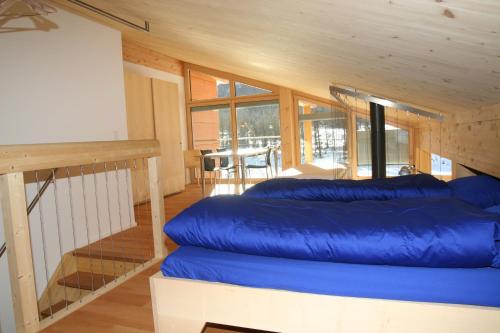 - un grand canapé bleu dans une chambre avec un escalier dans l'établissement Chesa Randurel, à Pontresina