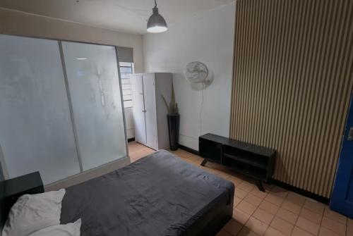 a bedroom with a bed and a fan at BluePepper City Hostel in Guadalajara
