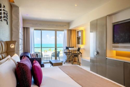 a hotel room with a bed with a view of the ocean at Planet Hollywood Cancun Adult Scene by Royalton, An Autograph Collection All-Inclusive Resort - Adults Only in Cancún