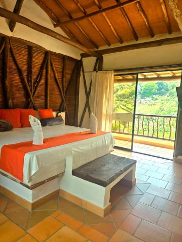 a bedroom with a bed and a large window at Cabañas el Nopal in San Gil