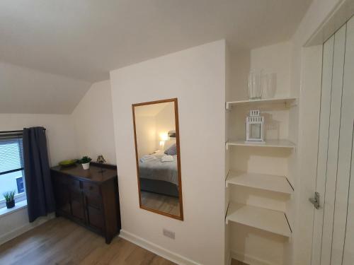 a bedroom with a mirror and a bed and a dresser at FLAT 2 Seven Cambrian Square First Floor Flat in Newtown