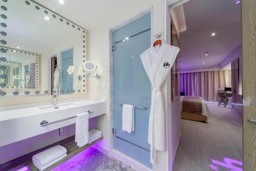 a bathroom with a white dress hanging on a door at Planet Hollywood Cancun Adult Scene by Royalton, An Autograph Collection All-Inclusive Resort - Adults Only in Cancún