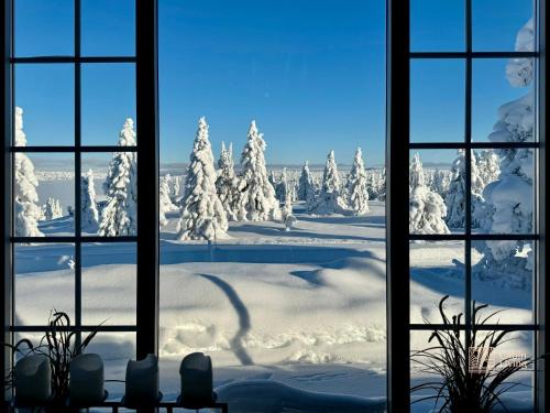 a view out a window of a snow covered yard at Authentic mountain atmosphere at Sjusjøen in Ringsaker