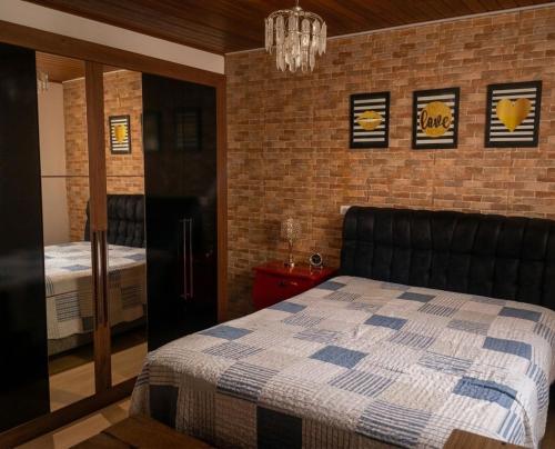 a bedroom with a bed and a brick wall at Chácara Carlópolis Pr in Carlópolis