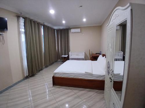 a hotel room with a bed and a television at Gosen Hotel Lubumbashi in Lubumbashi