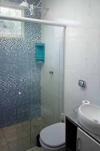 a bathroom with a shower and a toilet and a sink at Chácara Carlópolis Pr in Carlópolis