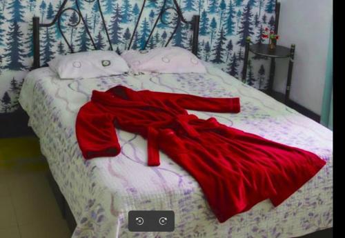 a red robe laying on top of a bed at TuKasa Boutique Liberdad - Buen cafe en Terraza Interior in Ayacucho