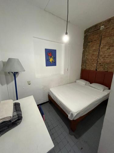 a bedroom with two beds and a lamp in it at BluePepper City Hostel in Guadalajara
