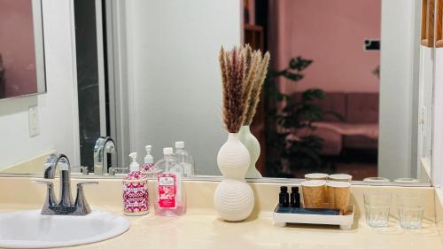 a bathroom counter with two white vases and a sink at Joshie home in Rancho Cucamonga