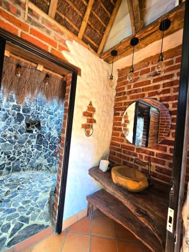 a bathroom with a stone shower with a wooden sink at Cabañas el Nopal in San Gil